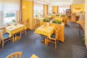 诺德代希Hotel Atlantis的餐厅设有桌椅和黄色的墙壁