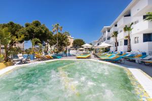 马盖鲁夫Sotavento Club Apartments - Adults Only的一个带躺椅的度假村的游泳池