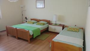 科普里夫尼察Apartment Cecilia Koprivnica的一间卧室配有两张床和一个带灯的床头柜