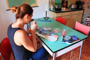 科莫勒达米德拉科尔塞拉住宿加早餐旅馆的坐在桌子上的带缝 ⁇ 机的女人