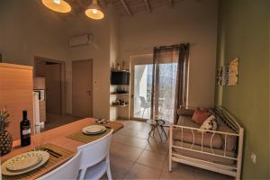 AyiáAksos Suites Accessible Accommodation的厨房以及带桌子和沙发的用餐室。
