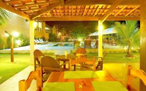 普拉杜古阿比巴宾馆的一个带桌椅的庭院和一个游泳池