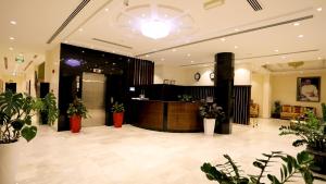 锡卜Remas Hotel Suites - Al Khoudh, Seeb, Muscat的大堂设有前台和盆栽植物