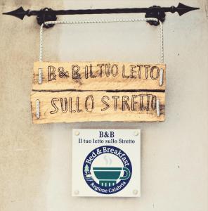 雷焦卡拉布里亚Il Tuo Letto Sullo Stretto的挂在墙上的标志,上面有苏拉街标志