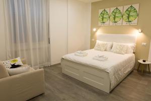 卡利亚里Sorores Bed&Breakfast的卧室配有白色的床和沙发