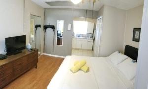 劳德代尔堡INN LEATHER GUEST HOUSE-GAY MALE ONLY的卧室配有白色大床和黄色毛巾