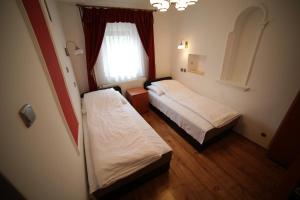 埃格尔Eged Vendégház的小型客房 - 带2张床和窗户
