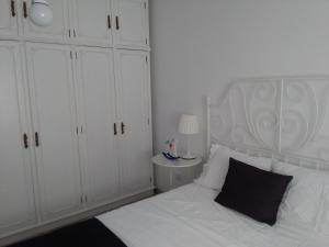 阿威罗Jardim à vista的卧室配有一张带黑色枕头的白色床