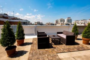 贝尔格莱德Arena Penthouse Apartments的屋顶庭院配有椅子、桌子和盆栽树木