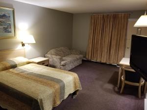 威廉斯莱克Slumber Lodge Williams Lake的酒店客房配有两张床和一张书桌