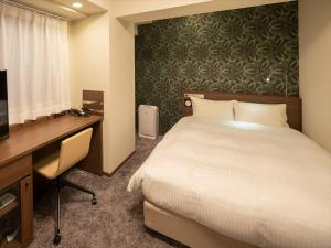 大阪WBF霍玛奇酒店的酒店客房配有一张床、一张书桌和一台电视。