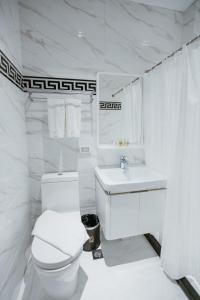 杜马格特PVL套房酒店的白色的浴室设有卫生间和水槽。