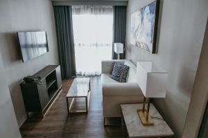 杜马格特PVL套房酒店的带沙发和电视的客厅