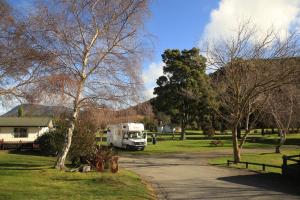 皮克顿帕克兰滨海假日公园酒店的停在一个树木繁茂的公园里的白色卡车