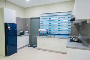 拉布安C Residence Labuan的厨房配有白色橱柜和蓝色的墙壁