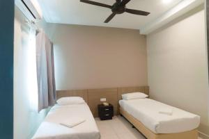 拉布安C Residence Labuan的配有吊扇的客房内的两张床