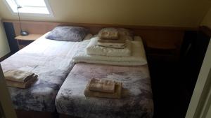 霍勒姆Appartement Senang, Resort Amelander Kaap的一间卧室配有带毛巾的床