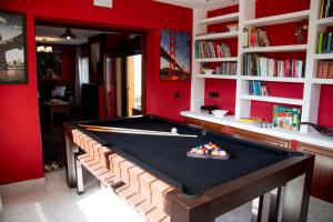 Collado MedianoCasa Rural Collarubio的红色墙壁的房间里设有一张台球桌