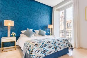 塞维利亚大教堂旁生活公寓的蓝色的卧室,配有一张蓝色墙壁的床