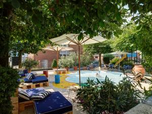 沃尔胡森August Restaurant Hotel的庭院内一个带椅子和遮阳伞的游泳池