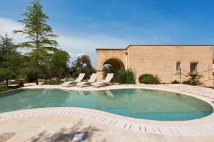 卡萨拉诺Villa Satis by BarbarHouse的一座带躺椅的游泳池和一座建筑