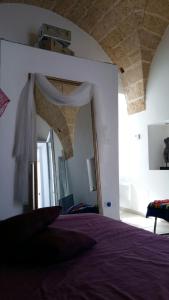 加利亚诺德尔卡波Palazzino in centro storico的一间卧室配有一张床和一面大镜子