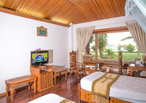 TaungooKMA Kaytumadi Hotel的一间卧室配有两张床和电视。
