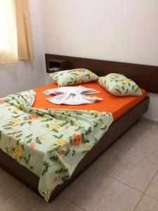 伊瓜苏沙兰迪酒店的一张带橙色毯子和枕头的床
