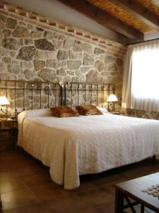 Arens de LledóHostal Casa Laure y Mª Jose的一间卧室设有一张带石墙的大床