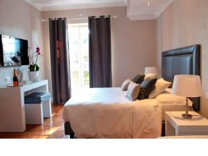 钱皮诺别墅套房酒店的一间卧室设有一张大床和一个窗户。