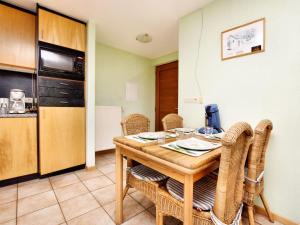 AmelscheidComfortable Holiday Home in St Vith的厨房以及带木桌和椅子的用餐室。
