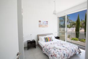 普罗塔拉斯Greco Villas的一间卧室设有一张床和一个大窗户
