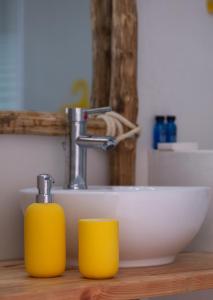 沃尔沃罗Casa di Greco的浴室设有水槽和2个黄杯