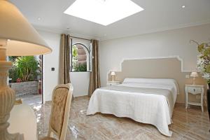 卡尔维木兰花酒店的白色的卧室设有床和窗户