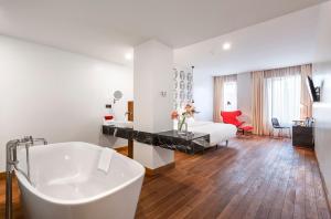 第比利斯索塔 @ 鲁斯塔韦力精品酒店的带浴缸的白色浴室和卧室