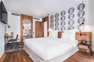 第比利斯索塔 @ 鲁斯塔韦力精品酒店的一间卧室配有一张白色的床和一面面朝墙壁