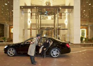 麦纳麦Gulf Hotel Bahrain的男人和女人从车里出来