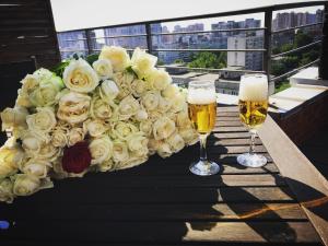 敖德萨人类迷你酒店的一束白玫瑰和两杯啤酒