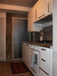 阿雷佐Casa enzo的厨房配有白色橱柜和炉灶烤箱。