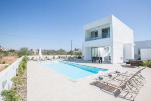 普罗塔拉斯Greco Villas的白色别墅 - 带游泳池和椅子