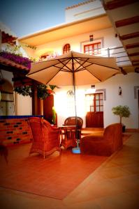 苏克雷拉艾斯康迪达旅馆的庭院配有两把椅子和一把遮阳伞