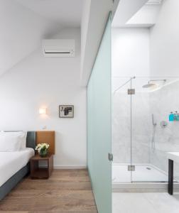 里斯本里斯本服务式公寓 - 希亚多埃门达的一间卧室设有淋浴、一张床和一个浴缸。