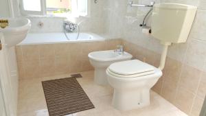 伊佐拉Guest House Izola的浴室配有卫生间、盥洗盆和浴缸。