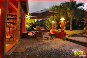 圣弗朗索瓦Sunset Surf Camp的庭院配有遮阳伞和桌椅。