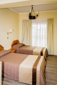安托法加斯塔Hotel Diego de Almagro Antofagasta Express的酒店客房设有两张床和窗户。