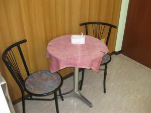 维拉·达尔梅卡萨久利酒店的一张桌子和两把椅子,上面有粉红色的桌布