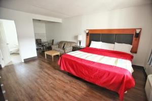 坎卢普斯坎卢普斯最佳经济及套房酒店 的一间卧室配有一张带红色毯子的大床
