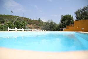 Sobreira FormosaAldeia Oliveiras的一座大型蓝色游泳池,后面设有白色椅子