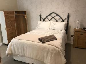 约克Thrush Nest Cottages - Wren Cottage sleeps 4, 2 bedrooms & Stable Cottage sleeps 2, 1 bedroom的一间卧室配有一张带棕色毛巾的床