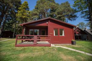 巴拉特Invercauld Lodges的红色小屋,在草地上设有野餐桌